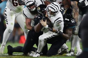 Jake Browning #6 of the Cincinnati Bengals is sacked by Travon Walker #44 and Josh Allen #41 of the Jacksonville Jaguars during the first quarter at EverBank Stadium on December 04, 2023 in Jacksonville, Florida.