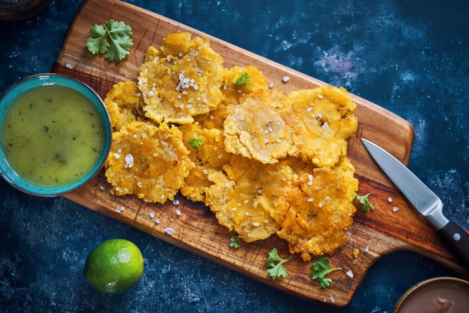 A platter of tostones with green salsa at a Puerto Rican restaurant