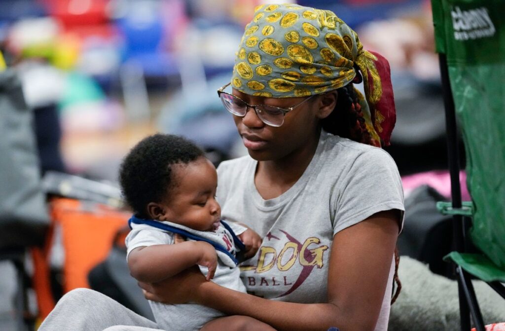 Katoria Harvey, of Tallahassee, sits with her niece Ny'Year Harvey, 3 months, inside a hurricane evacuation shelter at Fairview Middle School, ahead of Hurricane Helene,
