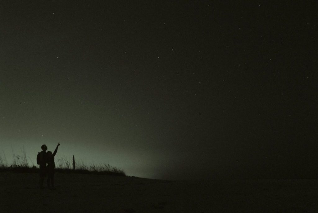 Silhouette of two people gazing at the stars.
